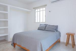 a white bedroom with a bed and a window at Casa completa con alberca en Chetumal in Chetumal +20 photos