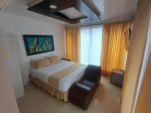 a bedroom with a large bed and a black leather chair at HOTEL DULCES SUEÑOS in Buenaventura +31 photos