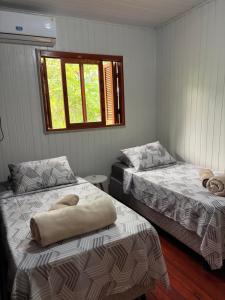 a room with two beds and a window at Casa da Serra borrussia in Osório