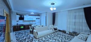 a living room with white furniture and a kitchen at Onur Termal in İhsaniye
