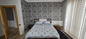a bedroom with a bed and a wall with curtains at Onur Termal in İhsaniye