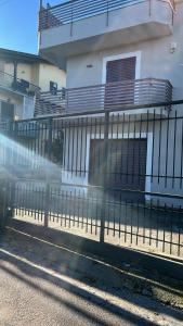 a fence in front of a building next to a building at Nancy's Home in Naples