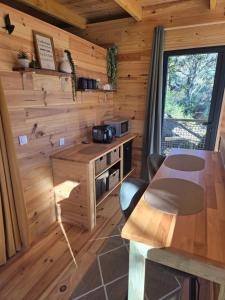 a kitchen in a log cabin with a table and chairs at La parenthèse in Ansignan