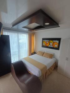 a bedroom with a large bed and a chair at HOTEL DULCES SUEÑOS in Buenaventura