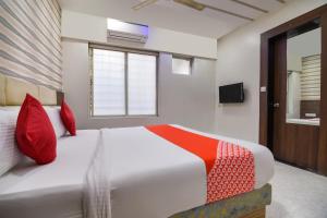 a bedroom with a large white bed with red pillows at Hotel O Sunshine Inn Near Pune Railway Station in Pune +30 photos