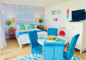 a bedroom with a bed and a table with blue chairs at Sweet Blue Hawaii in Honolulu +37 photos