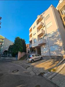 a car parked in a parking lot next to a building at Iskra Apartment 2 in Kragujevac