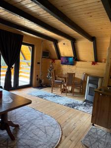 a living room with a table and chairs and a television at ROMANIJA vikendice in Koprivice