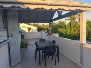 a patio with a table and chairs on a balcony at Spacious 2 beds flat in Grande-Terre center in Morne-à-lʼEau