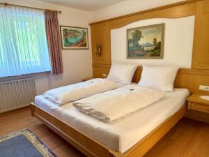 a bedroom with a large bed with white sheets at Ferienhaus Cosima in Schwangau