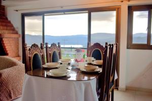 a wooden table with chairs and a table with a child sitting at it at Cabaña Campestre Bellavista in Paipa +31 photos