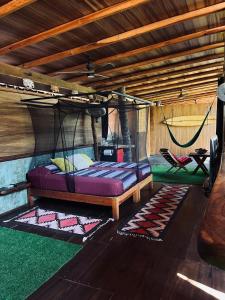a room with two beds and a hammock in it at Casa Frutas y Verduras in Puerto Escondido