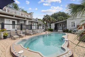 a swimming pool in a yard with chairs and a house at Awesome Downtown Condo with Pool! in Savannah