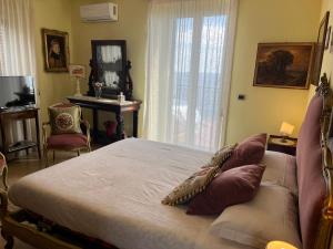 a bedroom with a bed and a table and a window at Miriam Sea Front Apartment Jacuzzi in Giardini Naxos