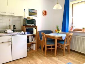 a kitchen with a table and chairs and a microwave at Ferienhaus Cosima in Schwangau