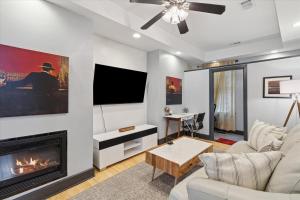 a living room with a fireplace and a tv at Awesome Downtown Condo with Pool! in Savannah
