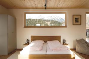 a bedroom with a bed with a window above it at Haus Gerti in Ramsau am Dachstein