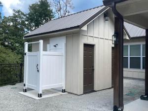 a large white garage with a door and a gate at Lakeside Oasis in Longtown