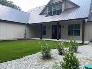 a house with a grass yard in front of it at Lakeside Oasis in Longtown