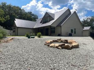 a large white barn with a large gravel driveway at Lakeside Oasis in Longtown