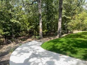 a driveway leading to a yard of grass and trees at Lakeside Oasis in Longtown