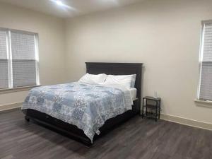 a bedroom with a bed with a blue blanket and two windows at Lakeside Oasis in Longtown +29 photos
