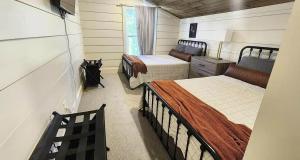 a small bedroom with two beds and a window at The Pointe Guesthouse in Texanna