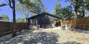 a house with a fence and two chairs in a yard at The Pointe Guesthouse in Texanna +12 photos