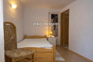 a bedroom with a bed and a chair at Pokój noclegowy in Józefowo