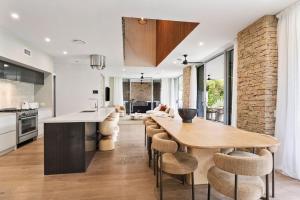 a kitchen and dining room with a wooden table and chairs at Beachfront Wellness Retreat in Kingscliff