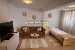 a small living room with a couch and a tv at Pokój noclegowy in Józefowo