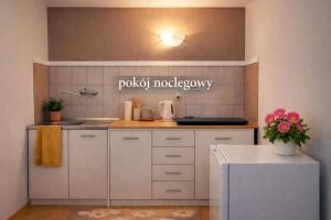 a kitchen with white cabinets and a sign that reads polka modularery at Pokój noclegowy in Józefowo