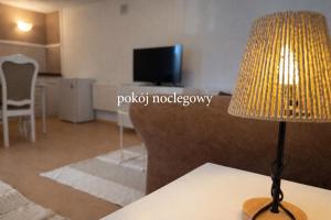 a lamp sitting on a table in a living room at Pokój noclegowy in Józefowo +7 photos