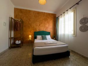 a bedroom with a bed with a green headboard and a window at mascot traditional guest house in Rhodes Town