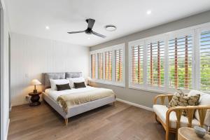 a bedroom with a bed and a couch and windows at Beachfront Wellness Retreat in Kingscliff +56 photos