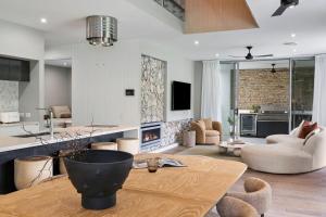 a living room with a table and a kitchen at Beachfront Wellness Retreat in Kingscliff