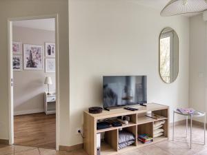 a living room with a tv and a mirror at Parisian escape near Disney - Liz Appart in Montévrain