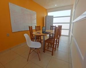 a dining room with a table with chairs and a laptop at Villa Platino Doble in Pachuca de Soto +6 photos