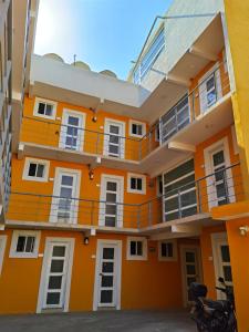 an orange building with white windows and balconies at Villa Platino Doble in Pachuca de Soto