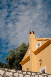 a yellow building with a sky in the background at Yioka House in Mikros Gialos