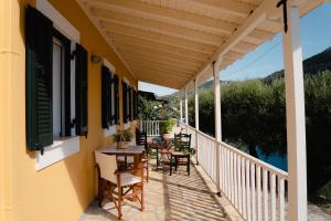 a patio with tables and chairs on a balcony at Yioka House in Mikros Gialos