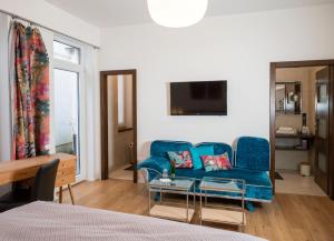 a living room with a blue couch and a table at Boutique Hotel Frieden in Weiden