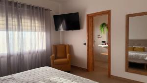 a bedroom with a bed and a chair and a mirror at Yellow Room - Sunlite Double Private Room in Villa Barbuja in Tefía