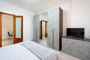 a bedroom with a bed and a flat screen tv at Station House Center in Cisterna di Latina