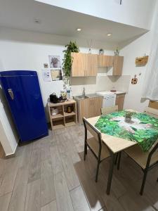 a kitchen with a table and a blue refrigerator at DAREB HOME vista mare in Agrigento