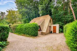 a small house with a straw roof at Riet&Rust in Lanaken