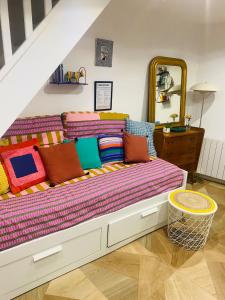 a large bed with colorful pillows in a room at Duplex house with small terrace in Bayeux