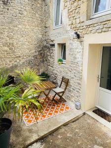 a wooden bench sitting next to a brick building at Duplex house with small terrace in Bayeux