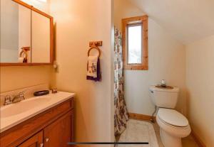 a bathroom with a toilet and a sink and a window at Sunset Serenity on Kego Lake in Fifty Lakes +45 photos