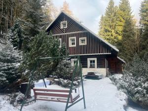 a swing in front of a house in the snow at Chata u Maršíků in Strážné